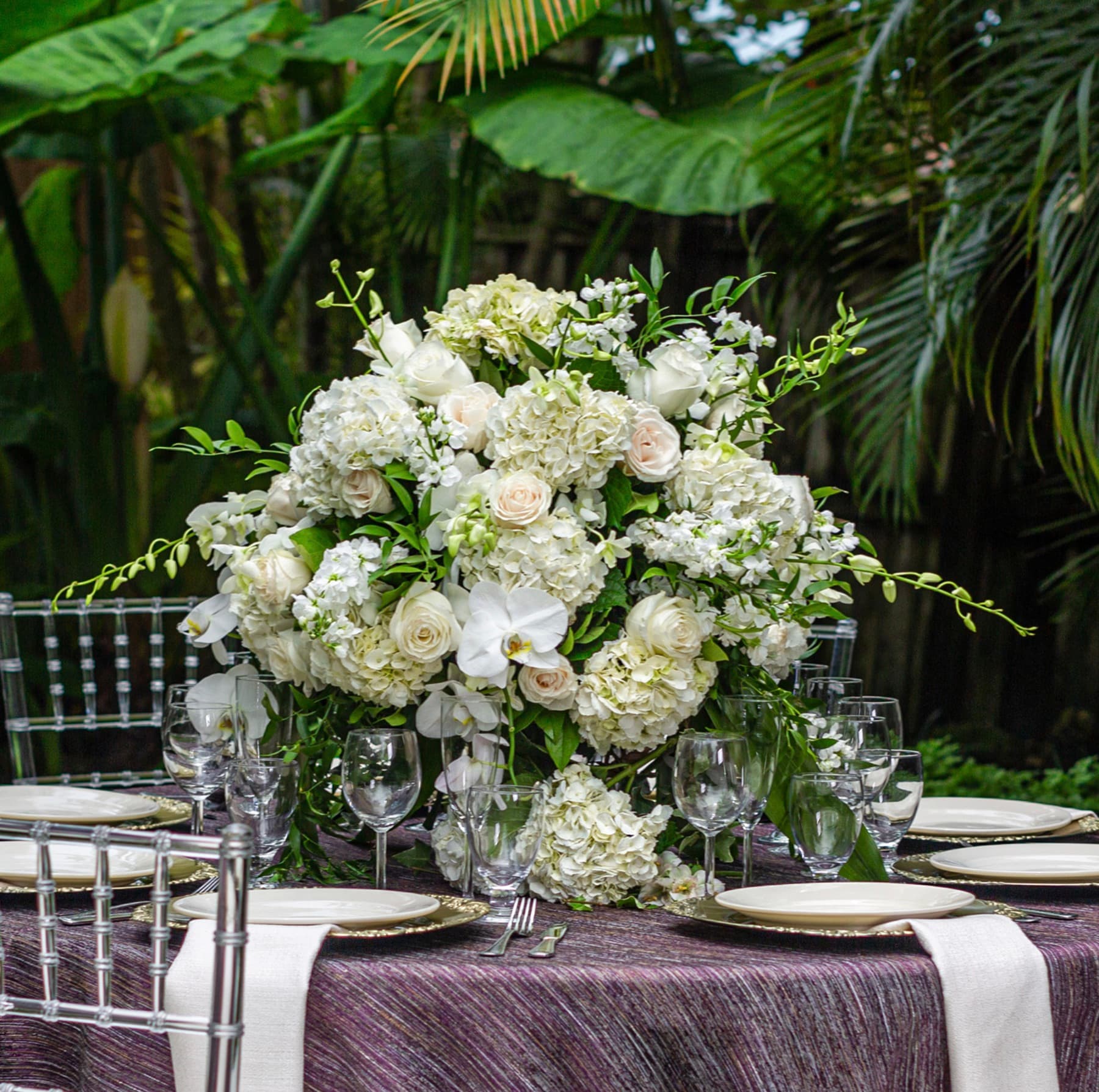 White floral centerpiece on an elegant celebration tablescape