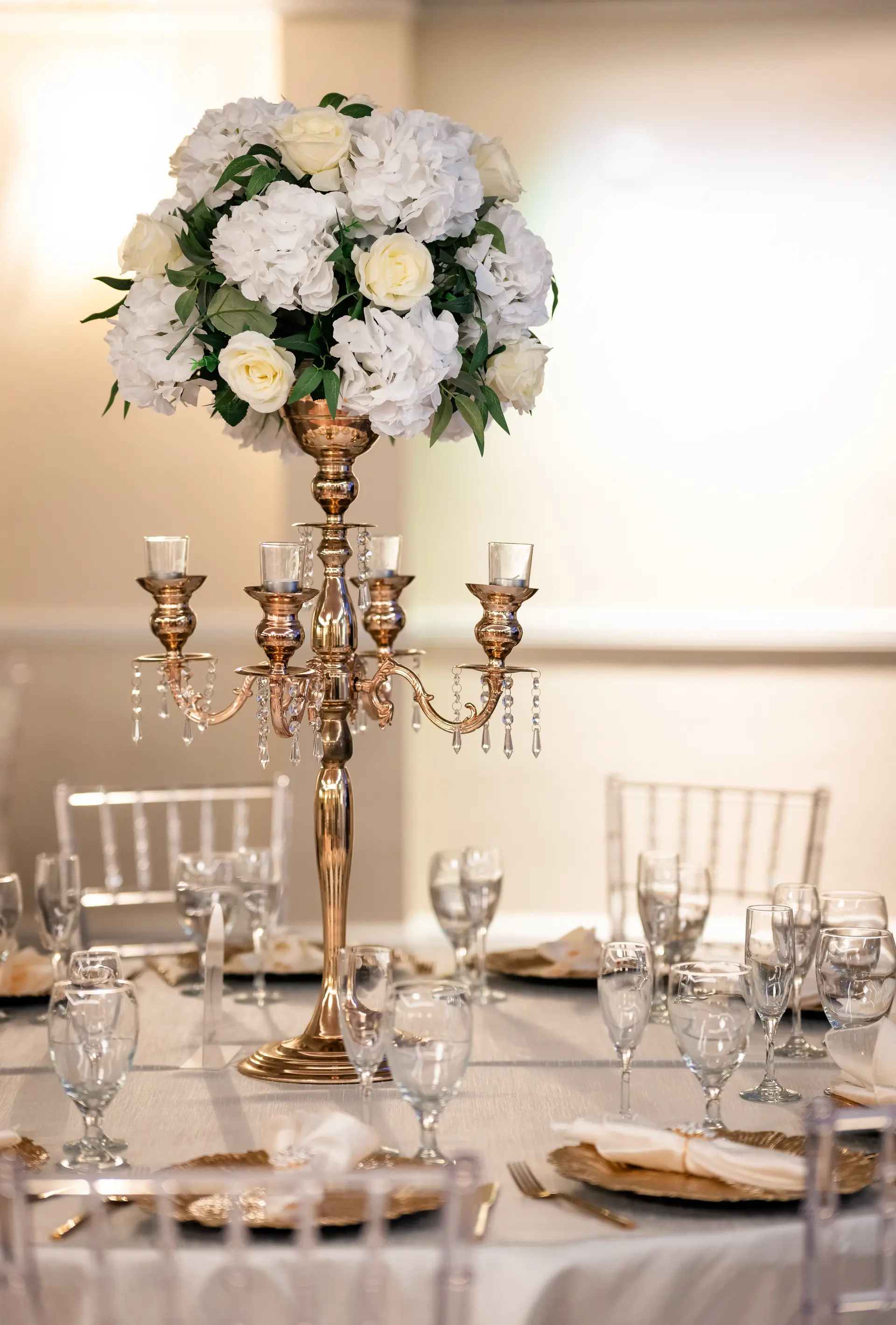 Tall gold candelabra centerpiece with white florals at La Vie